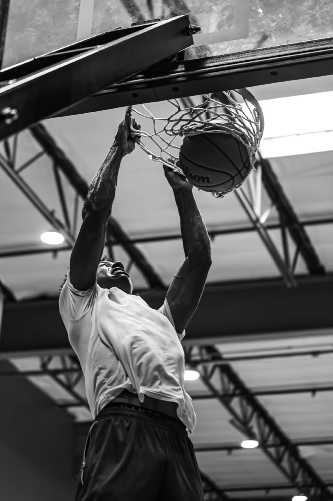 Finishing a two-handed dunk at the rim
